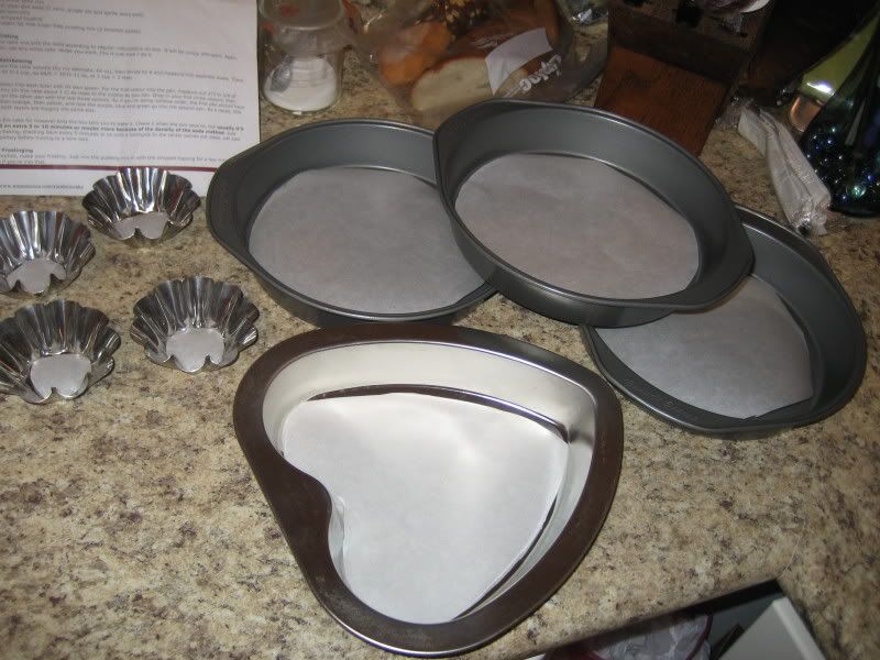Rainbow Cake pans lined with parchment, one heart shape, 3 rounds