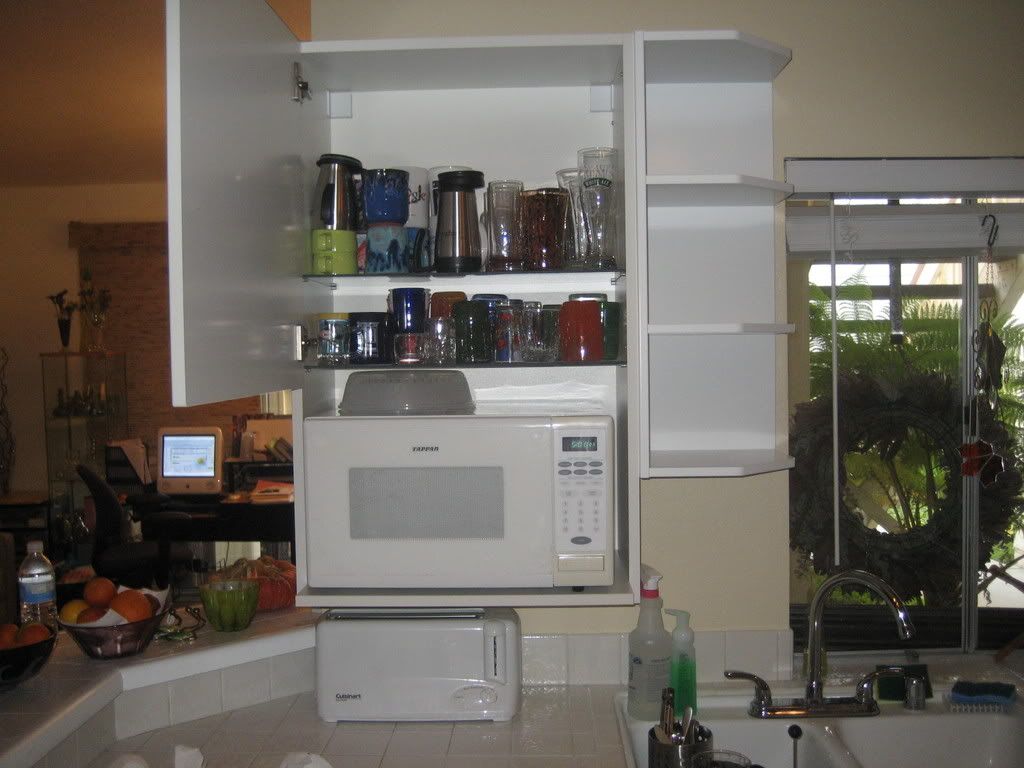 cabinet with microwave and glasses in it