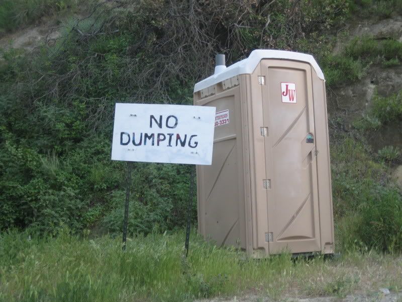 scenic port a potty with large No Dumping sign