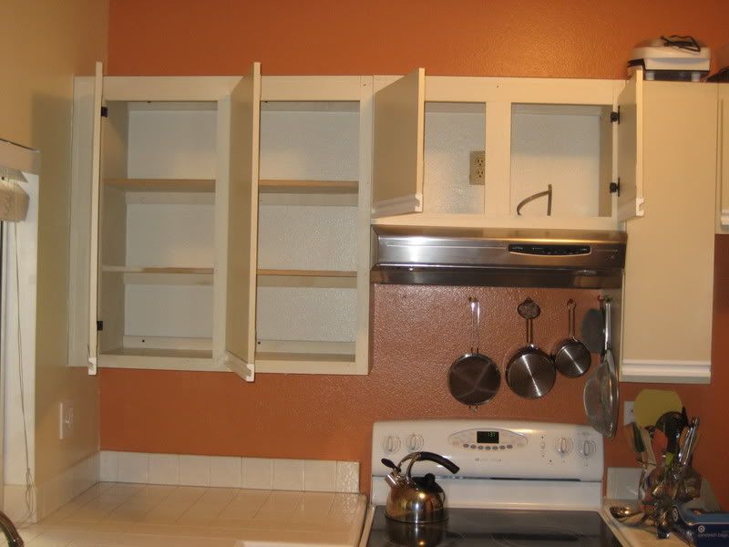 old kitchen cabinets with doors open and two adjacent left hinged doors in the corner