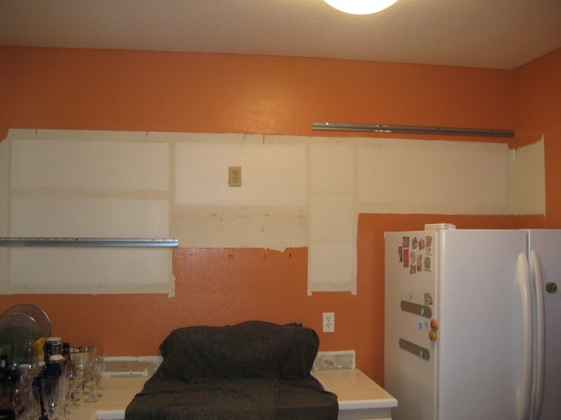 bare kitchen wall with orange and white paint areas