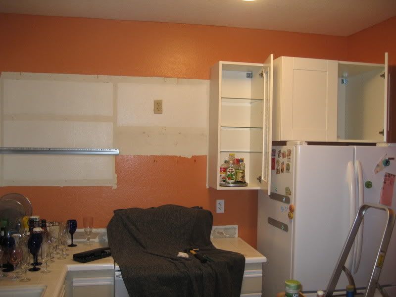 New kitchen cabinets open over fridge and near stove showing off supplies on lazy susan