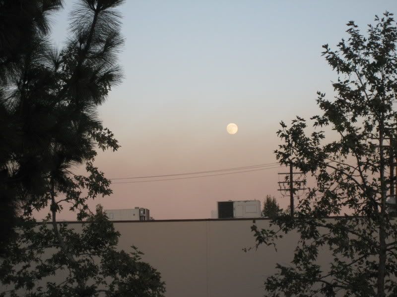 smoke settling over valley beneath full moon