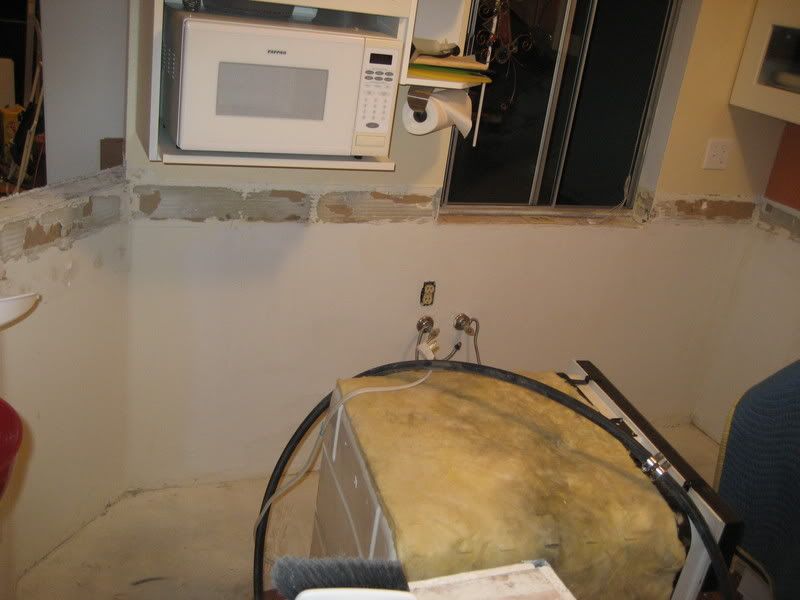 empty kitchen wall with pipes and floating dishwasher.