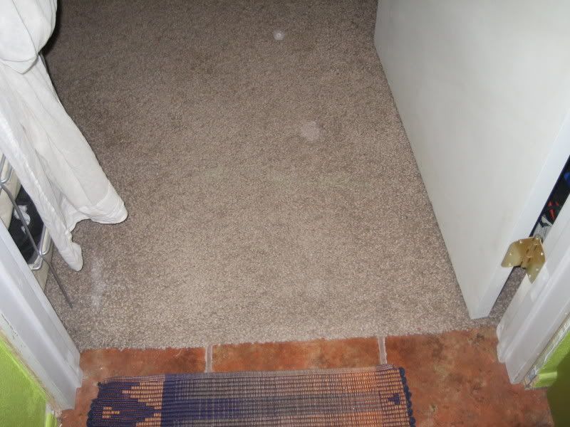 old greyish beige carpet with hole
