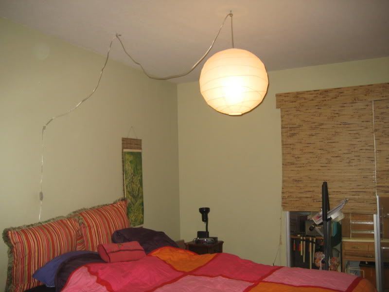 white paper lamp hanging from ceiling by droopy cord