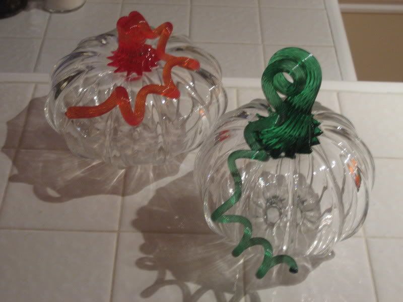 clear glass pumpkins with orange and green stems