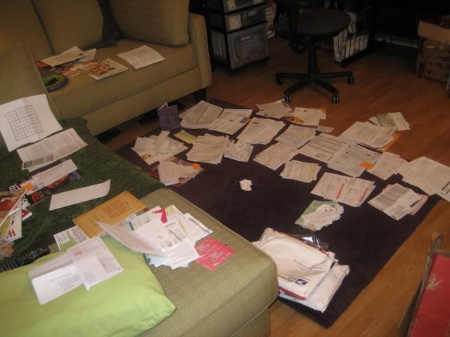 living room with bills and paperwork laid out everywhere