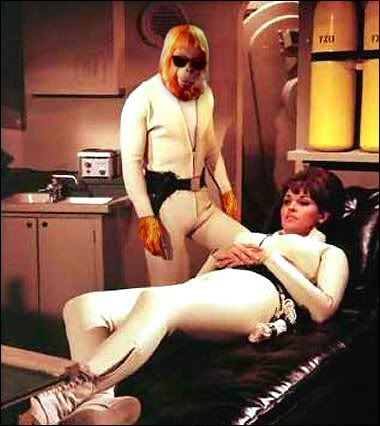 Raquel Welch and Dr. Zaius in tight white rubber wetsuits.